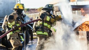 Brandweerlieden bestrijden een felle brand met een krachtige waterstraal
